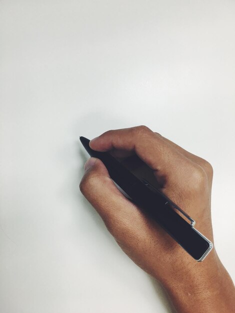 Photo close-up of hand writing against white background