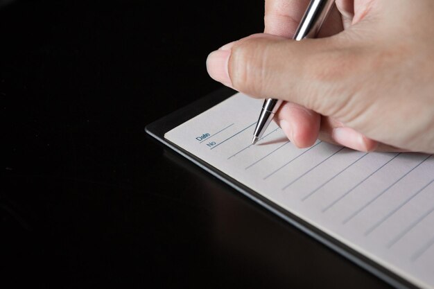 Photo close-up of hand writing on book