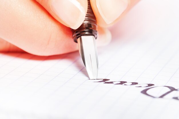 Photo close-up of hand writing in book