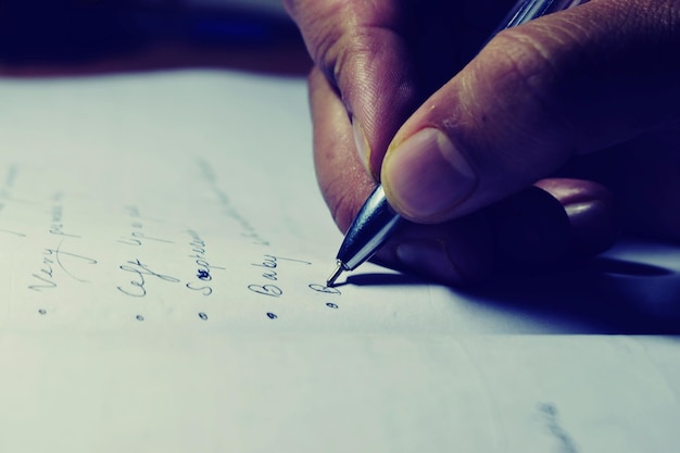 Close-up of hand writing on paper