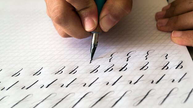 Photo close-up of hand writing on a paper