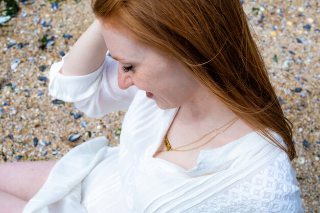 Foto primo piano mano giovane donna spiaggia mare capelli rossi sole nord sabbia bianco vestito scheveningen gen haag