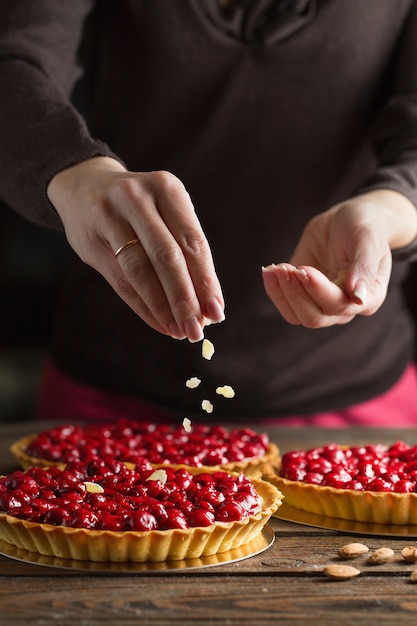 Close-up handen besprenkeling cake met amandelspaanders