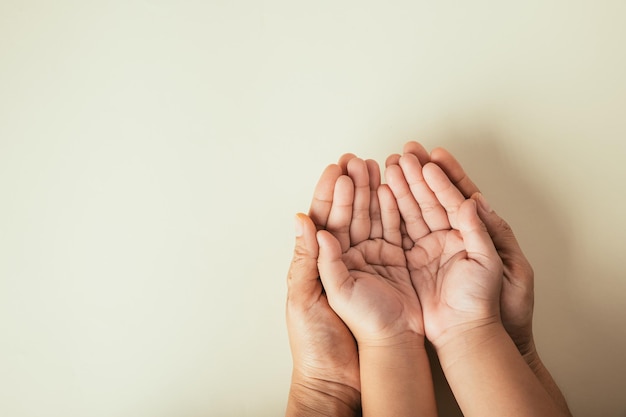 Close-up handen kinderen op volwassen moeder hand