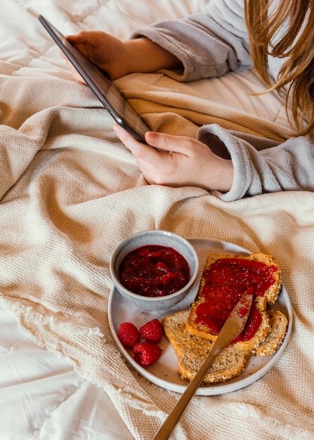 Close-up handen met tablet in bed