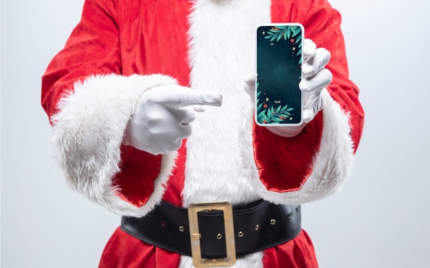 Close-up handen van de kerstman met apparaat met stijlvol design op het scherm, copyspace. Concept van winterverkoop, nieuwjaar 2021 en kerstviering, modern apparaat en gadgets, online winkelen.