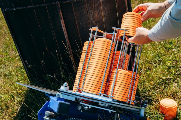 Close-up handen van werknemer laden plat machine met oranje schieten plaat