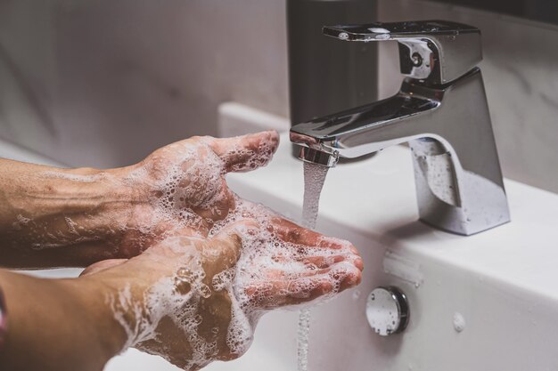 Close-up handen wassen met Chrome kraan en zeep voor Coronavirus pandemie