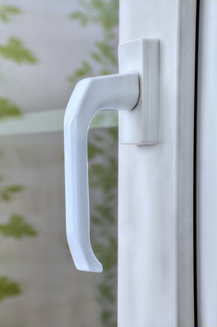Photo close-up handle of pvc window locking mechanism with double glazing.