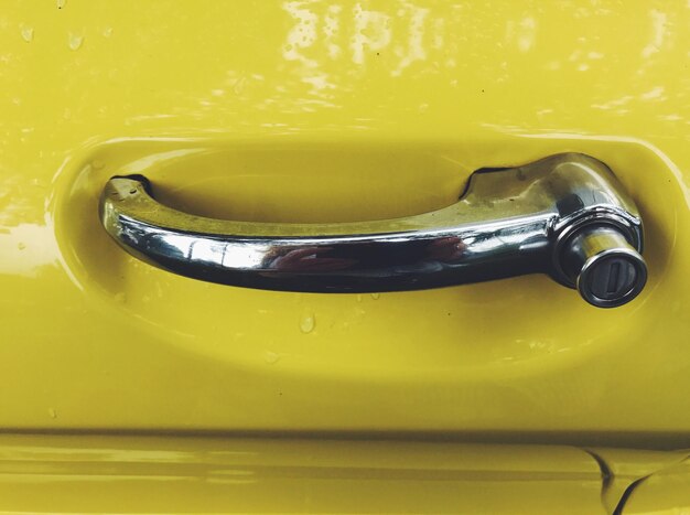 Close-up of handle on yellow car door