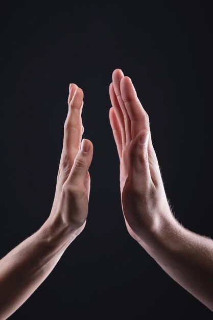 Close-up of hands against black background