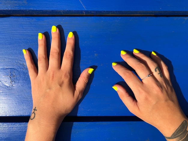 Close-up of hands against blue sky