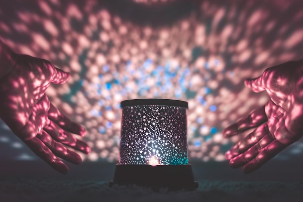 Photo close-up of hands around illuminated lantern