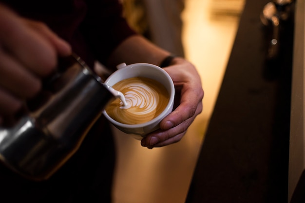 Close-up of hands barista making late art