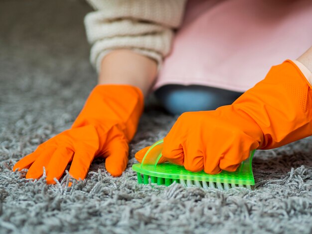 Foto moquette di spazzolatura delle mani del primo piano