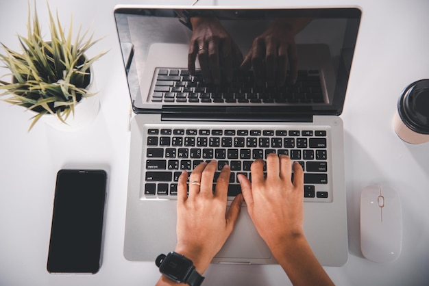 Close up Hands of business woman over laptop keypad during working at desk