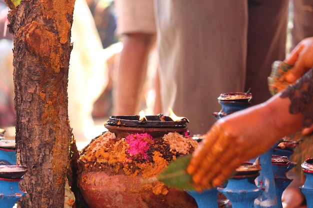 Photo close-up of hands by earthen pot at temple