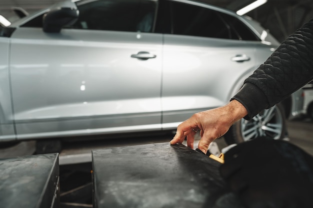 Chiuda in su delle mani del meccanico di auto nel servizio di riparazione auto