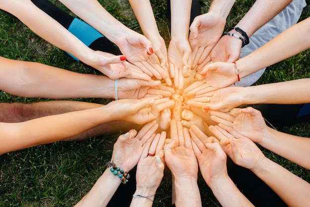 Close-up of the hands of children doing yoga in the open air during the sunset. Healthy lifestyle, meditation and Wellness.