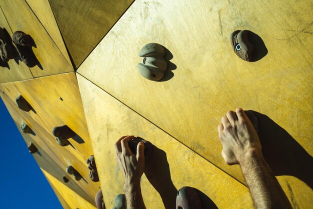 Close-up of hands climbing wall