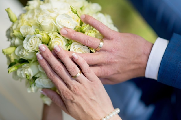 Foto prossimo piano delle mani della coppia al matrimonio.