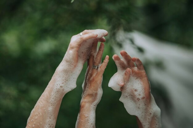 Foto close-up di mani ricoperte di sapone