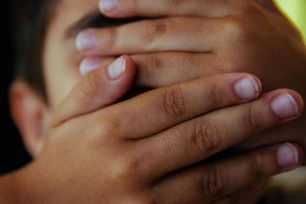 Close-up of hands covering face