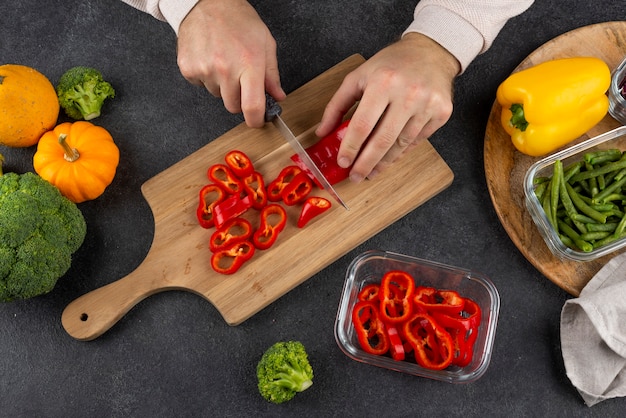 Photo close up hands cutting pepper