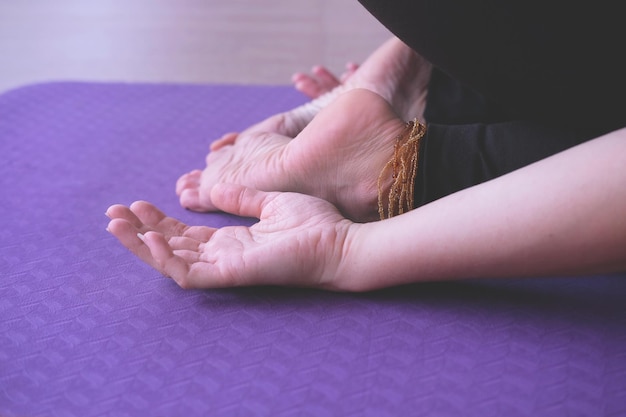 子供のポーズ balasana ヨガのコンセプトでヨガを練習している女性の手と足のクローズ アップ