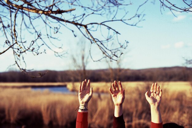 Photo close-up of hands on field against sky