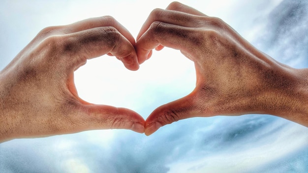 Photo close-up of hands forming heart shape