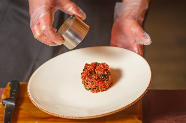 Close-up. Hands in the frame. The chef prepares a delicious dish.