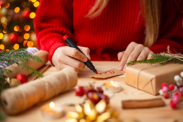 Close up of hands of a girl signing Christmas present
