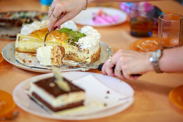 Foto close-up di mani che tengono la torta servita sul tavolo