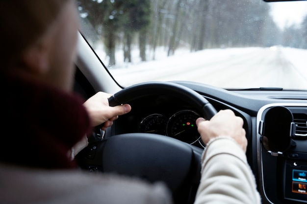 Foto chiuda sulle mani che tengono il volante dell'auto