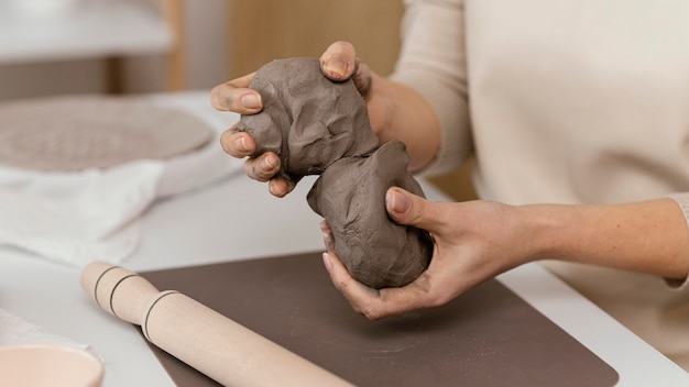 Close-up hands holding clay indoors