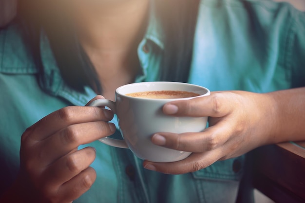 Photo close-up of hands holding coffee cup