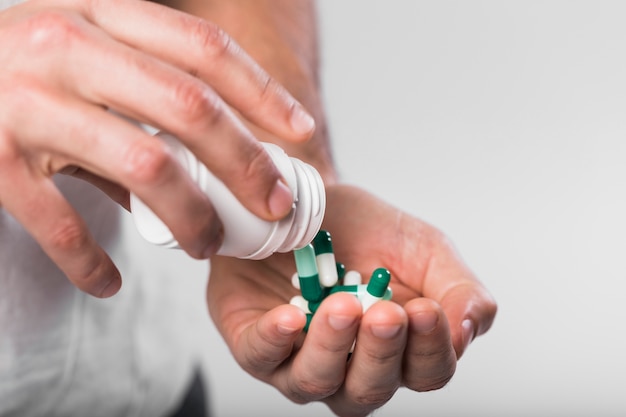 Photo close-up hands holding colorful capsules