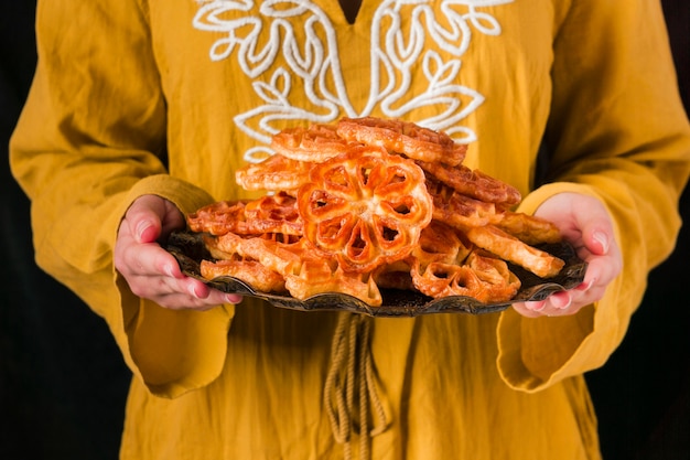 Foto mani del primo piano che tengono il piatto dell'alimento