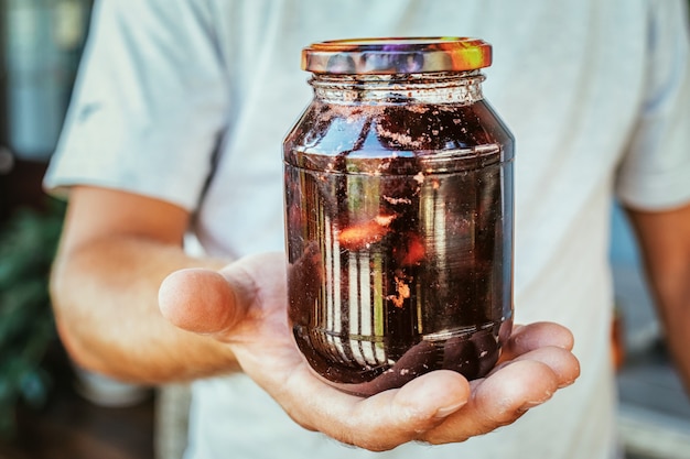 Close up of hands holding a jar of peach jam