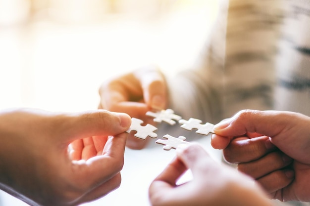 Foto close-up di mani che tengono i pezzi del puzzle