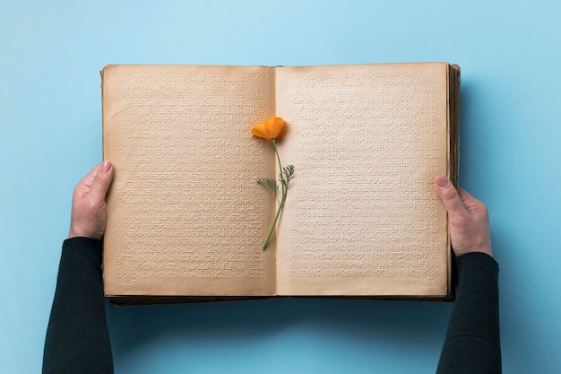 Foto mani del primo piano che tengono vecchio libro