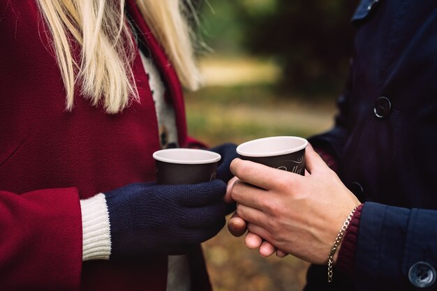 Close up of hands holding paper cups of coffee