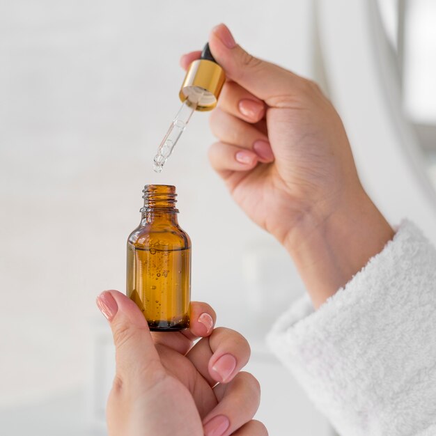 Close-up hands holding serum