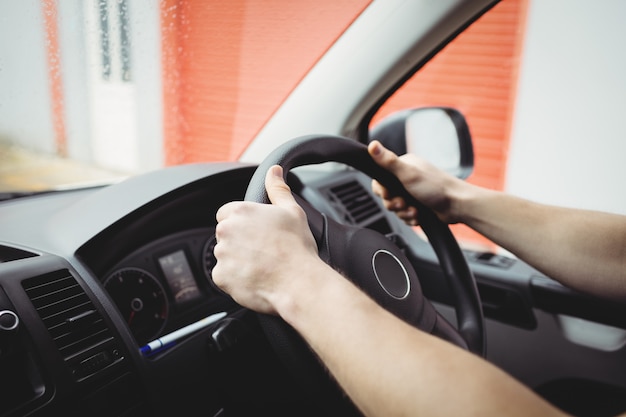 Close-up of hands holding steering wheel of a van