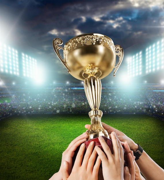 Close-up of hands holding winning cup against white background