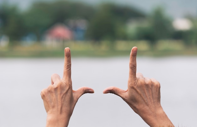 Close up of hands making frame gesture. Close up of woman hands making frame gesture with sunset.