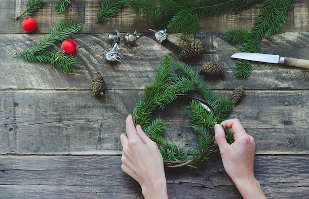 Close up on hands making natural pine crown