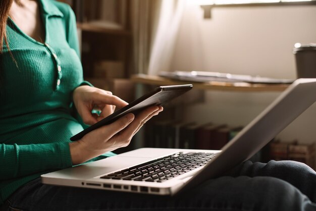 Close up hands multitasking women using tablet and laptop connecting wifi