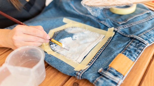 Foto mani del primo piano che dipingono i jeans